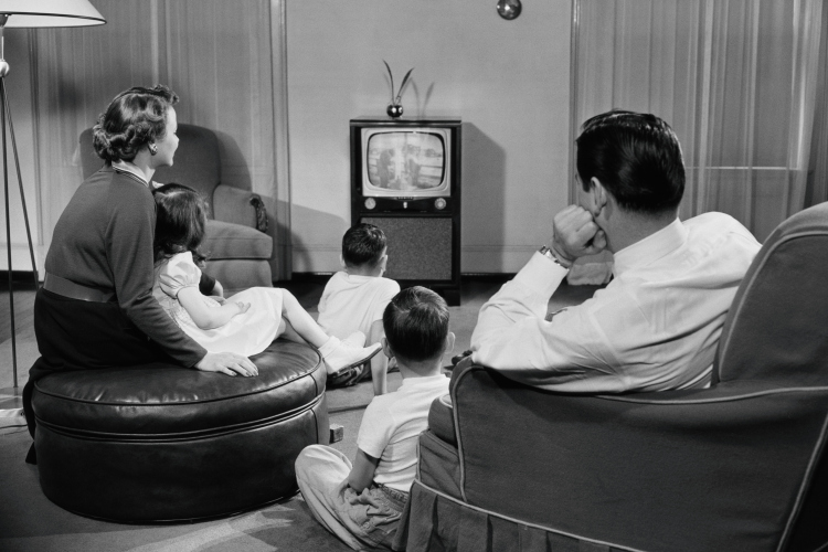 FAMILY WATCHES TV IN LIVING ROOM IN THE 1950'S
